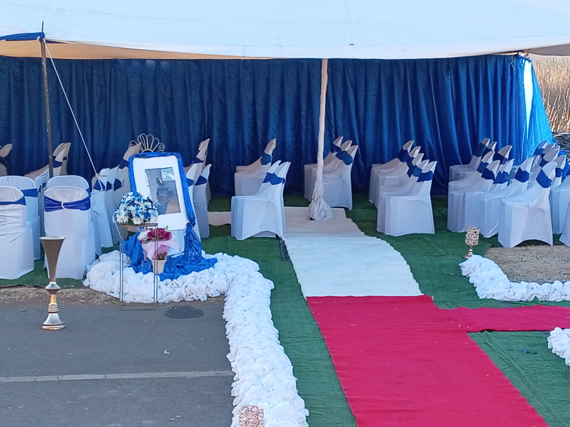 Tent interior with covered chairs, sashes and memorial display