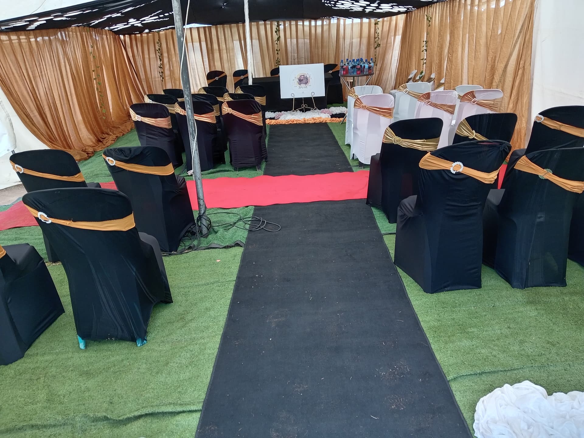 Black chair covers with gold sashes and a black aisle runner